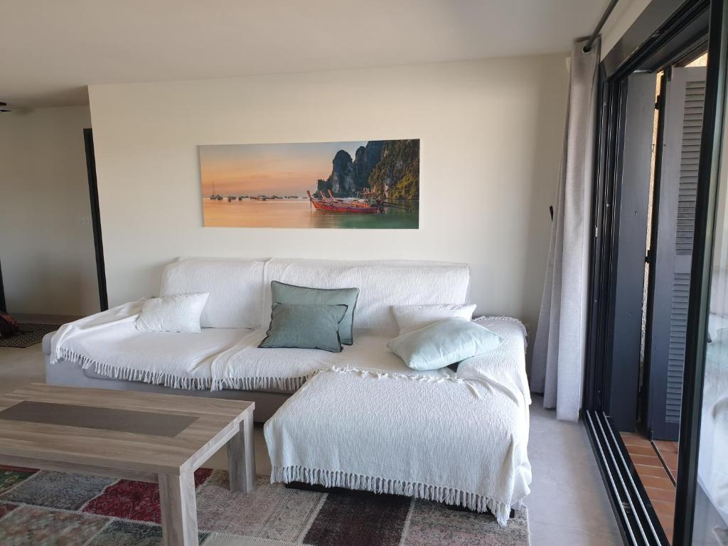 sala de estar con sofá blanco y mesa en Magnifique 2 pièces vue port et mer en Cogolin