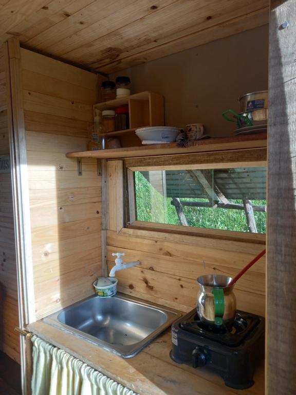 una cocina con fregadero en una casa pequeña en casita en la montaña, cabañas paraíso, en Sesquilé