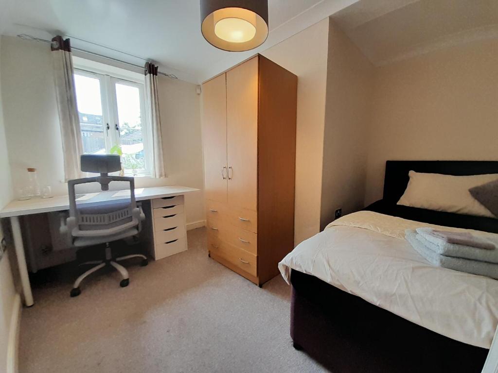 1 dormitorio con cama, escritorio y silla en Private rooms in a shared house in Oxford - Host lives in the property en Oxford
