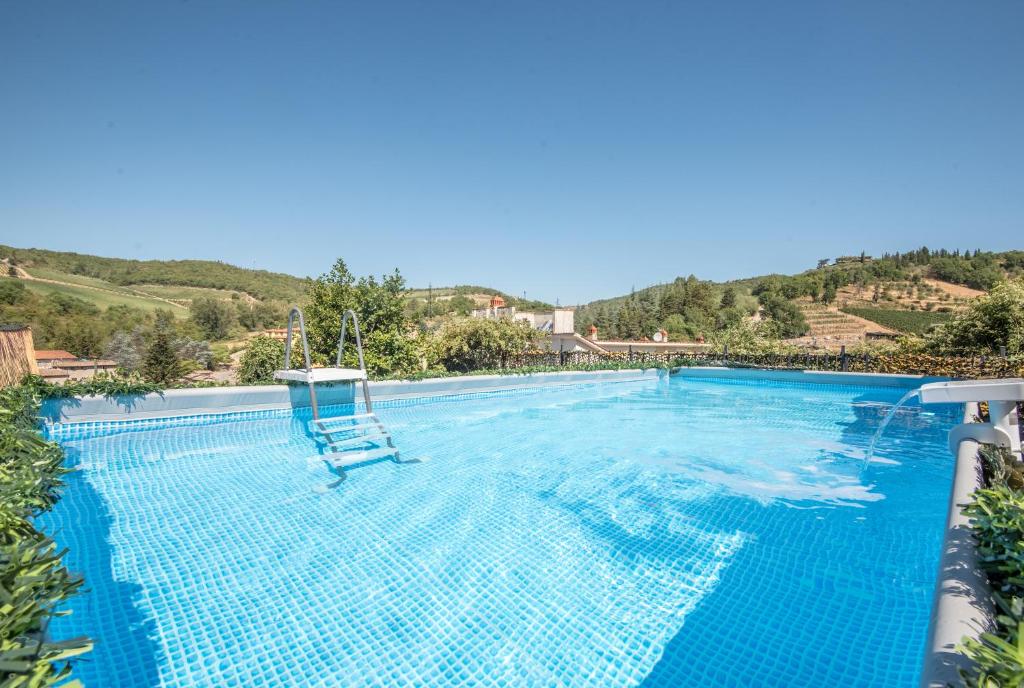 une piscine bleue avec une chaise au milieu dans l'établissement Casa Vacanze Chianti Summer, à Gaiole in Chianti