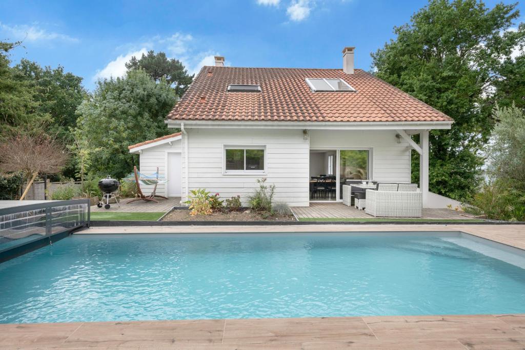 a house with a swimming pool in front of a house at Magnifique maison avec piscine in La Baule