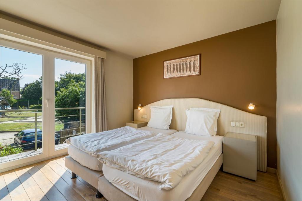 1 dormitorio con cama grande y ventana grande en Logie Bloemenlust en Wetteren