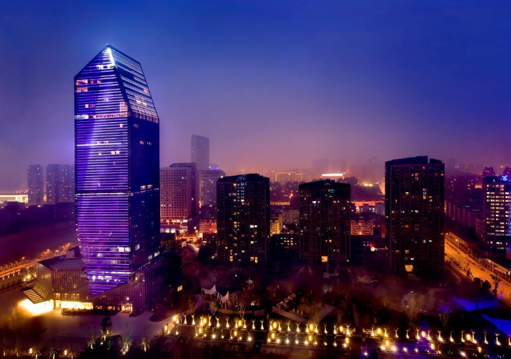 un perfil urbano por la noche con un rascacielos alto en Nanyuan Universe Deluxe Hotel, en Ningbo