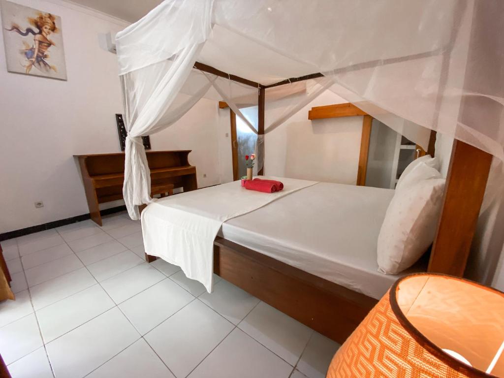 a bedroom with a bed with a canopy at Gili Spoy-Spoy in Gili Islands