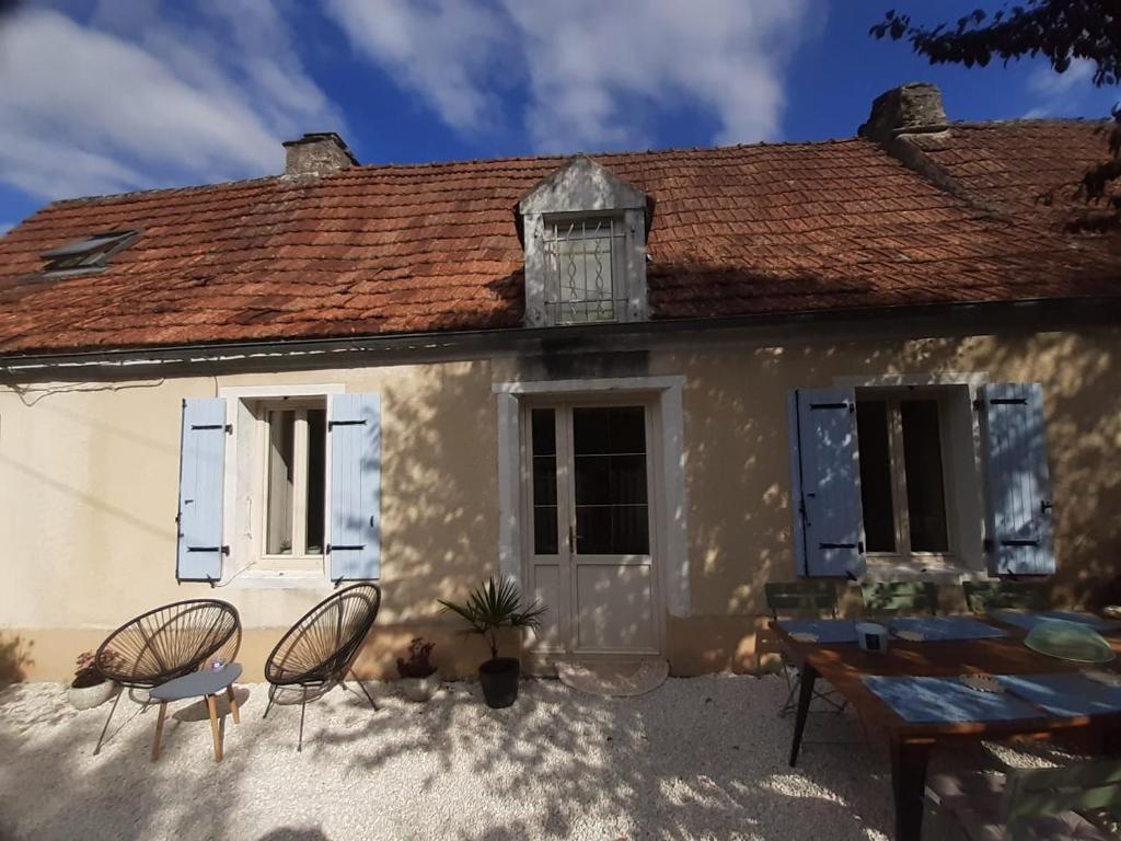 a white house with two chairs and a table at Maison Marilene in Ajat
