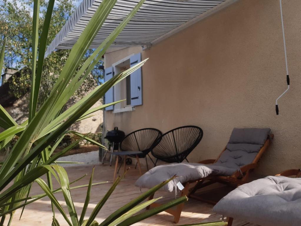 a patio with chairs and a couch and a plant at Maison Marilene in Ajat