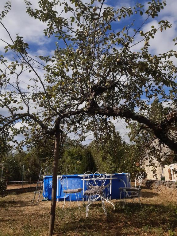 a blue table and chairs under a tree at Maison Marilene in Ajat