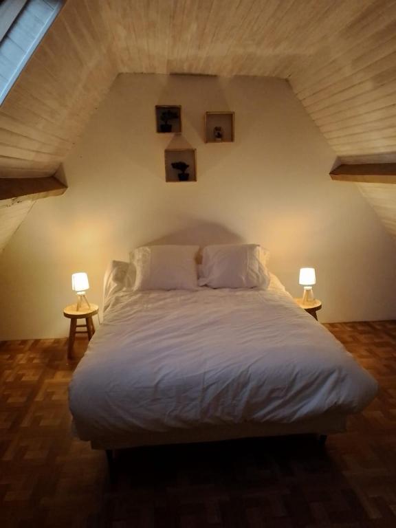 a bedroom with a white bed with two lamps at Maison Marilene in Ajat