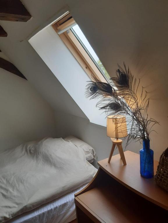 a bedroom with a bed and a lamp on a table at Maison Marilene in Ajat