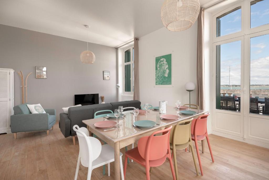 een woonkamer met een eettafel en stoelen bij Bel appartement vue sur le port du Croisic in Le Croisic