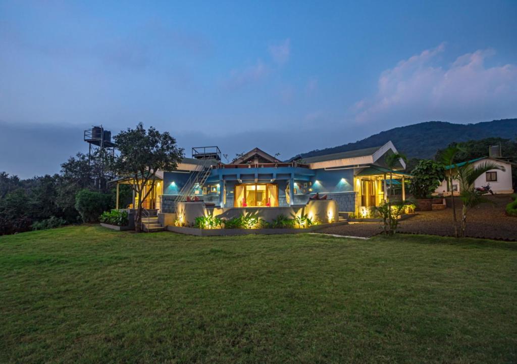 une maison avec une grande cour la nuit dans l'établissement SaffronStays Aatman, Mahabaleshwar - luxury estate with al-fresco dining amidst nature, à Mahabaleshwar
