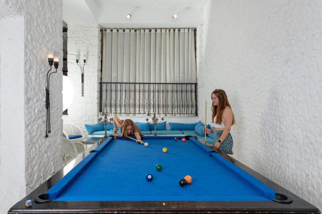 two women playing pool on a pool table at CHARM BEACH HOTEL in Akyarlar