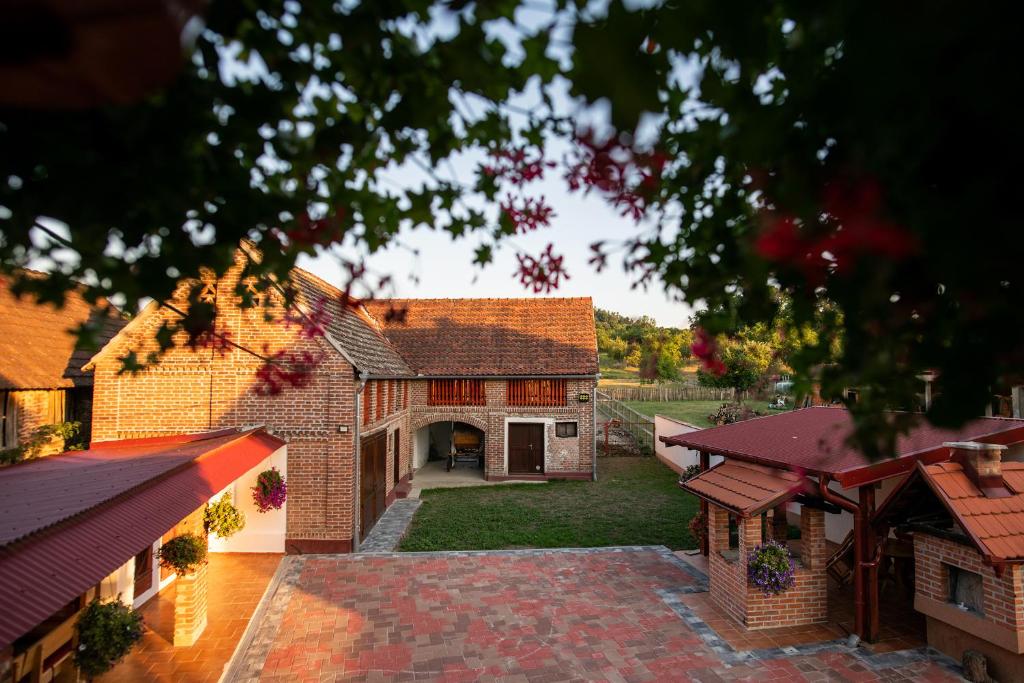 uma vista aérea de uma casa de tijolos com um pátio em Salaš 318 - B&B Farm Experience em Drenovac