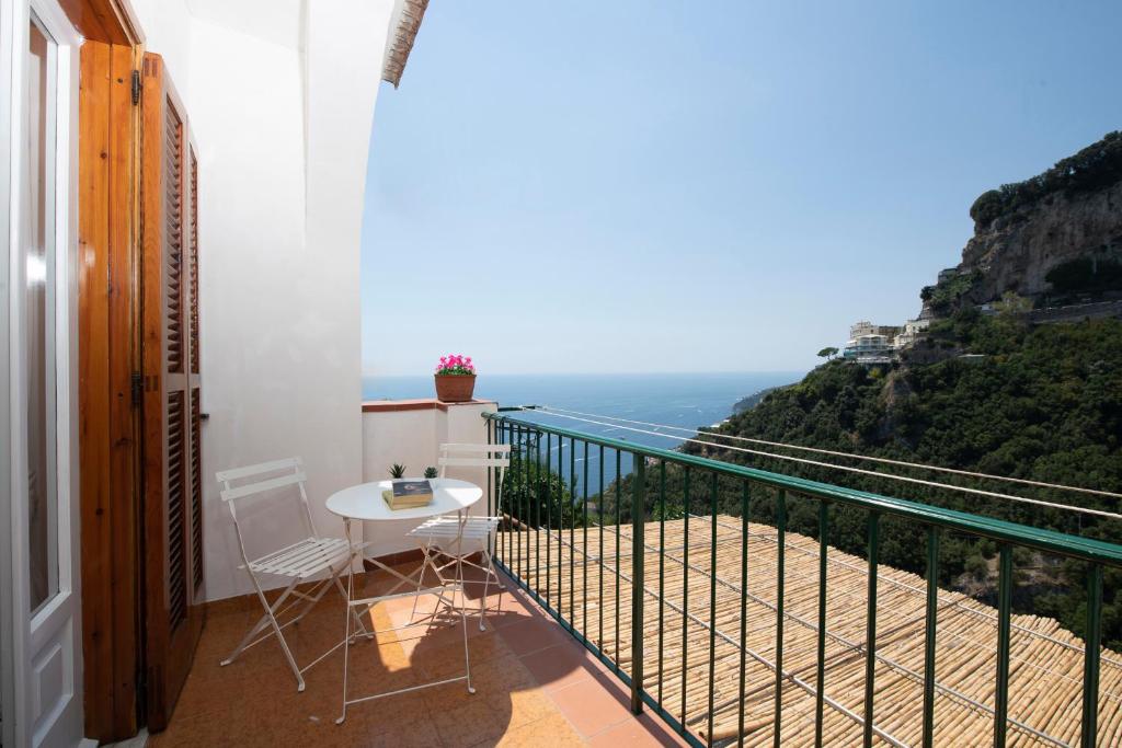 a balcony with a table and chairs and the ocean at Amalfi Venere house -balcony & seaview in Amalfi