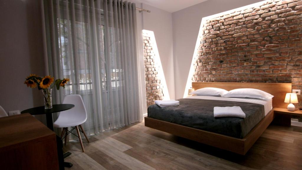a bedroom with a brick wall and a bed at KONI's Studio Apartments in Tirana