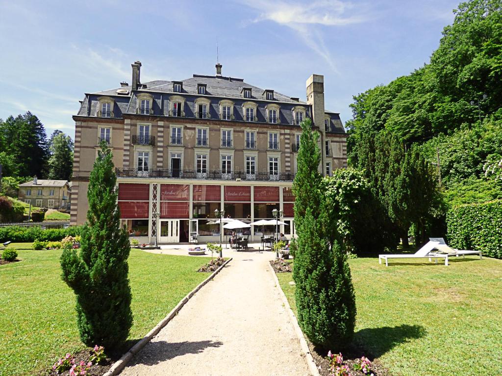 プロンビエール・レ・バンにあるLe Grand Hotel de Plombières by Popinnsの目の前に木々が生い茂る大きな建物