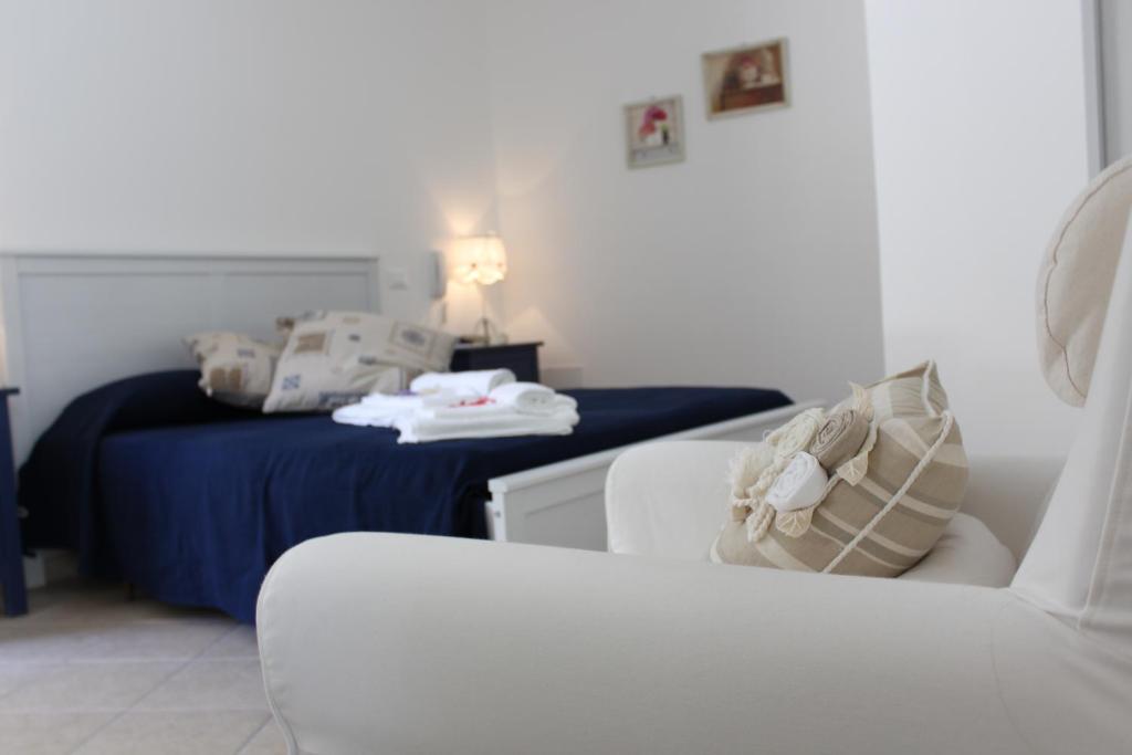 a living room with a bed and a white couch at Book and Bed in Maglie