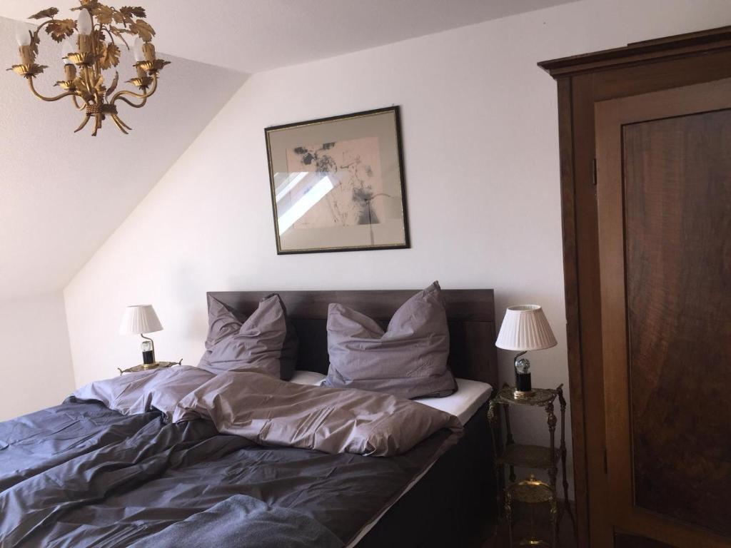 a bedroom with a bed and two lamps and a chandelier at Stillvoll Wohnen mit Fahrradweg zum Festspielhaus in Heinersreuth