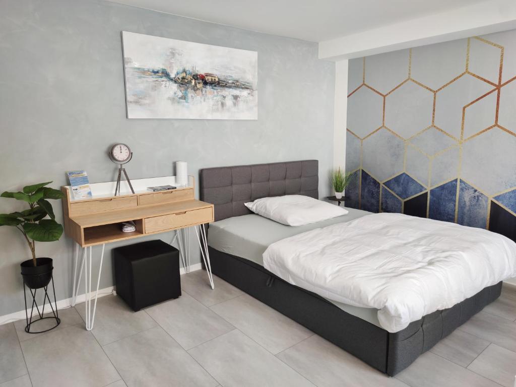 a bedroom with a bed and a wooden desk at Business Style Apartment Ludwigshafen *Free Parking and WiFi* in Ludwigshafen am Rhein