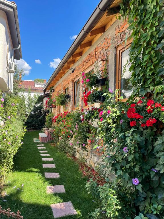 einen Garten mit Blumen an der Seite eines Gebäudes in der Unterkunft Flower House in the City Center! in Pristina