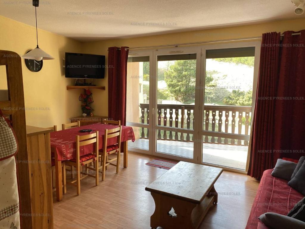 a living room with a dining table and a balcony at Appartement Les Angles, 3 pièces, 6 personnes - FR-1-295-183 in Les Angles