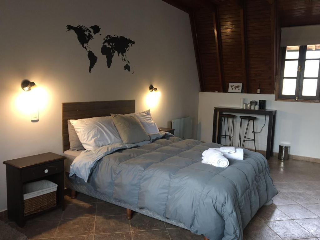 um quarto com uma cama com um mapa do mundo na parede em Casa Verde Palmares em Godoy Cruz