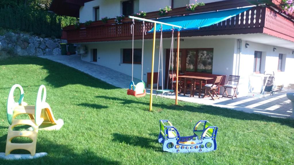 a yard with playground equipment in front of a house at Apartma Lara in Bled