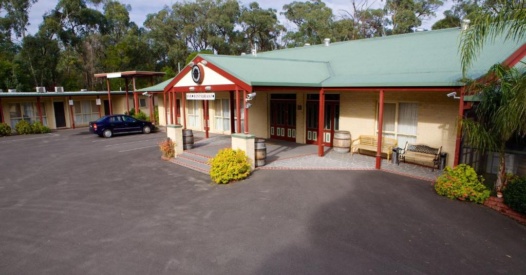 ein Gebäude mit einem Auto auf einem Parkplatz in der Unterkunft Sanctuary House Resort Motel in Healesville