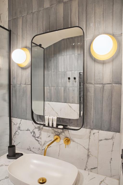 a bathroom with a sink and a mirror at Martis Forum Heritage Hotel & Residence in Poreč