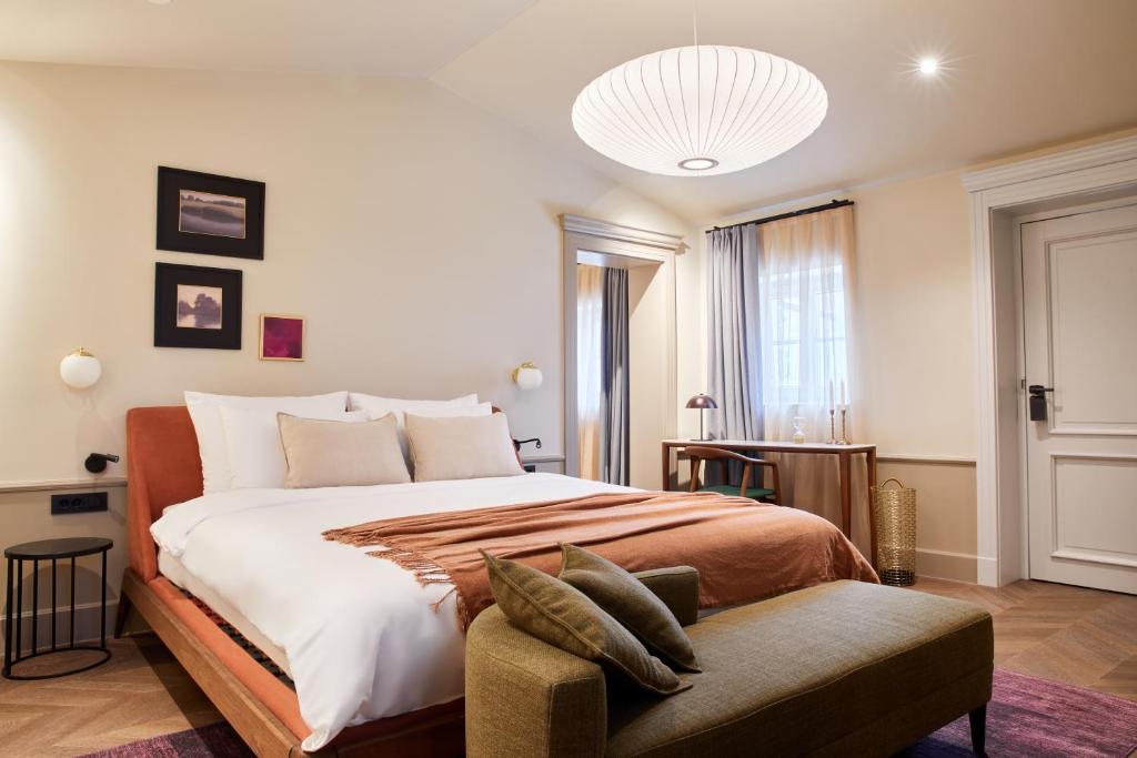 a bedroom with a large bed and a couch at Martis Forum Heritage Hotel & Residence in Poreč