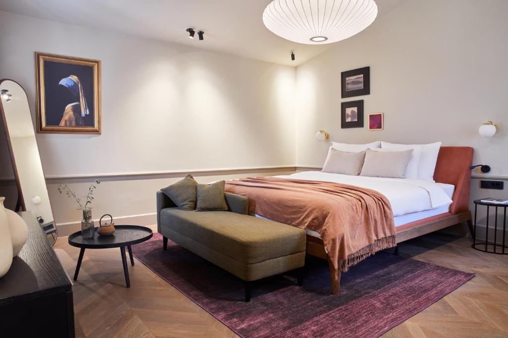 a bedroom with a large bed and a chair at Martis Forum Heritage Hotel & Residence in Poreč