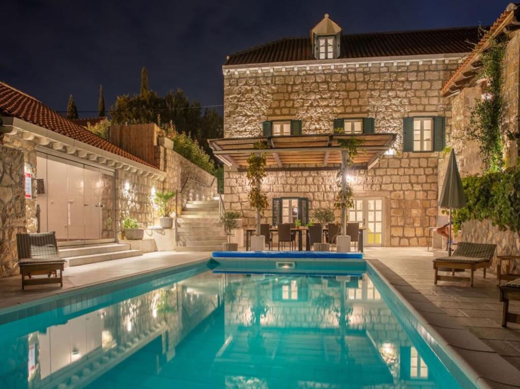 a villa with a swimming pool at night at Villa Joe in Čilipi