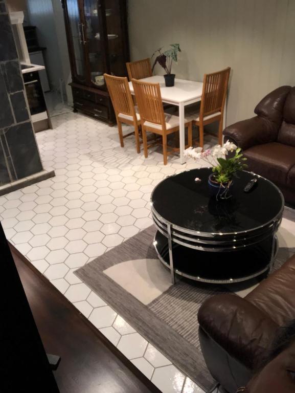 a living room with a couch and a table and chairs at Basement Apartment Varadero in Lyngdal