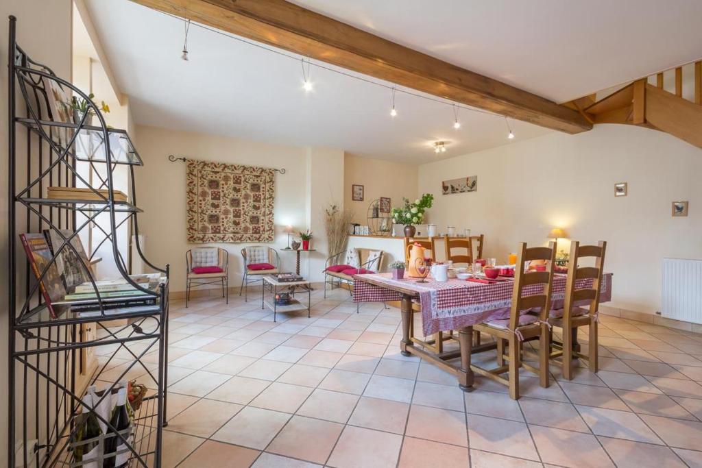 a large living room with a table and chairs at Logis de l'Orme in La Rochepot