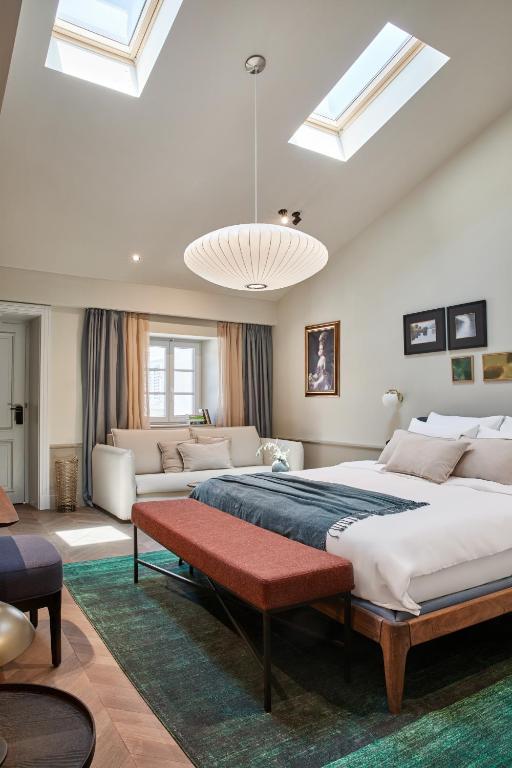 a large bedroom with a large bed and a couch at Martis Forum Heritage Hotel & Residence in Poreč