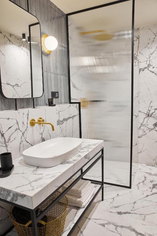 a bathroom with a sink and a mirror at Martis Forum Heritage Hotel & Residence in Poreč