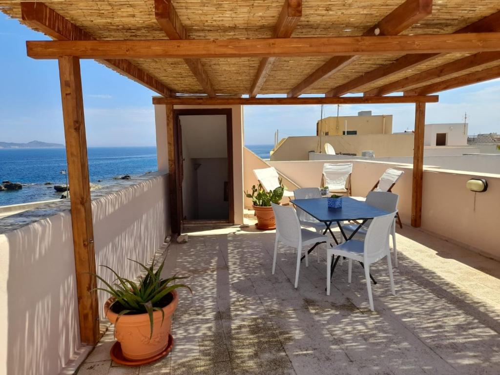 a patio with a table and chairs and the ocean at Casa Clio in Favignana