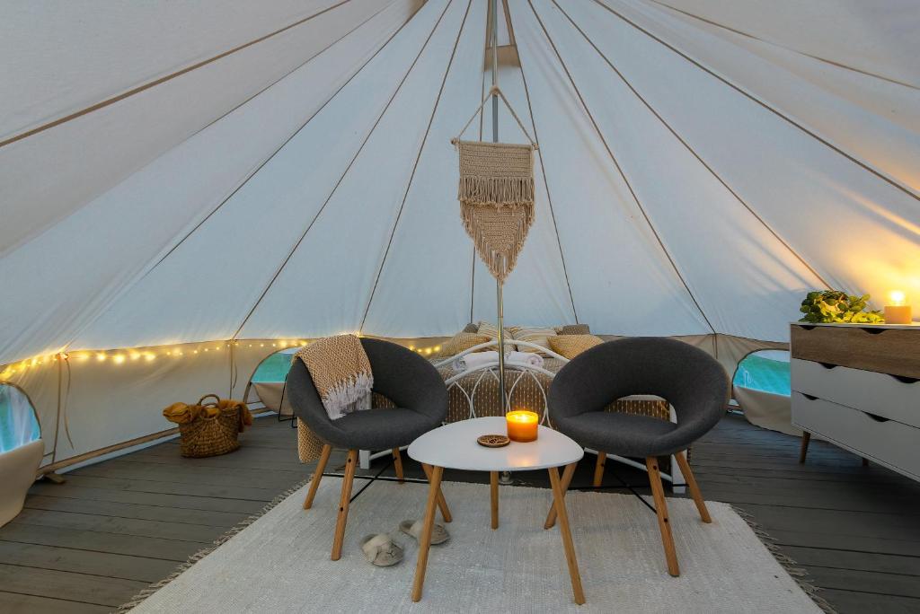 een kamer met stoelen en een tafel in een tent bij Glempings Laimes Taure in Vabole