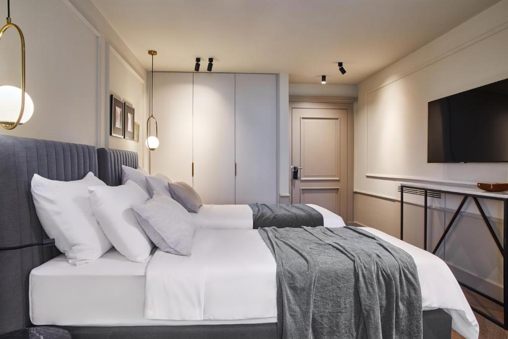 a bedroom with a white bed with white pillows at Martis Forum Heritage Hotel & Residence in Poreč