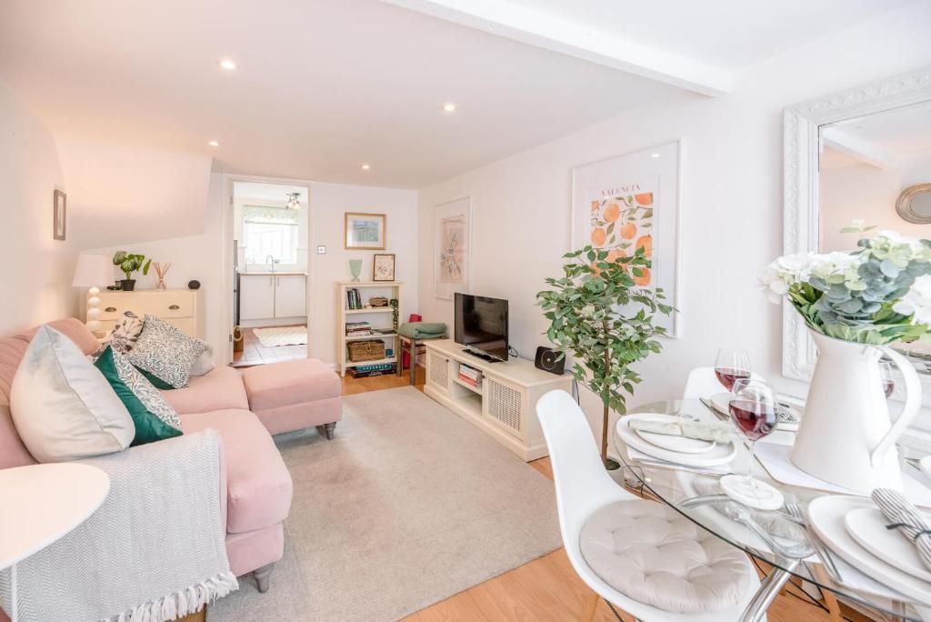 a living room with a couch and a table at Holly Cottage in Bury Saint Edmunds