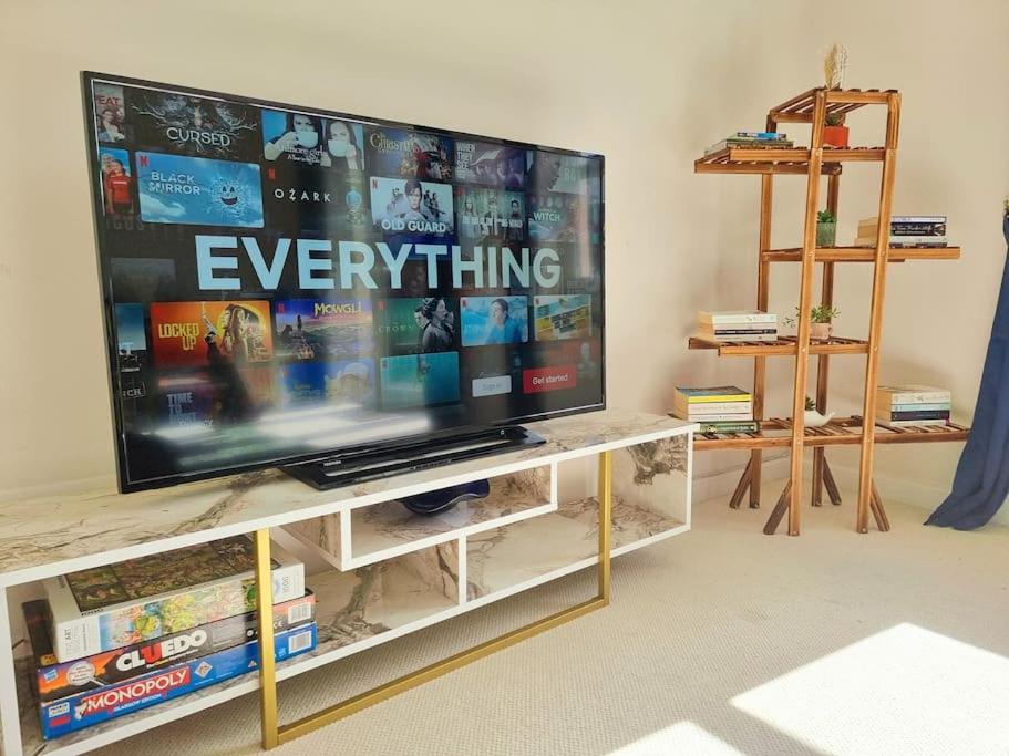 einen Flachbild-TV auf einem Entertainment-Center in der Unterkunft Homely Three Bed Holiday Home in Glasgow in Glasgow