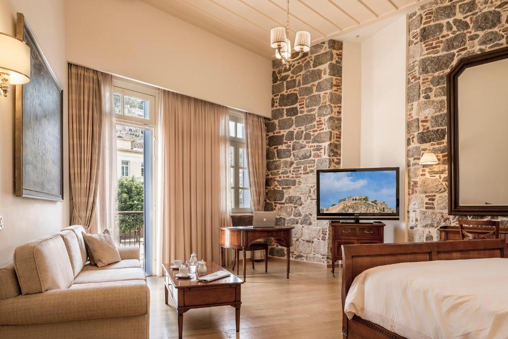 Habitación de hotel con cama y TV en Xenon Inn en Nafplio