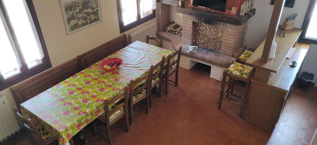 a dining room with a table and chairs and a kitchen at Appartamento Arcobaleno in Folgaria