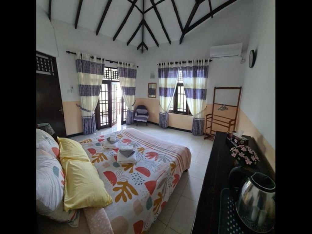 Un dormitorio con una cama grande en una habitación. en Ja-Elas French Touch 5, en Negombo