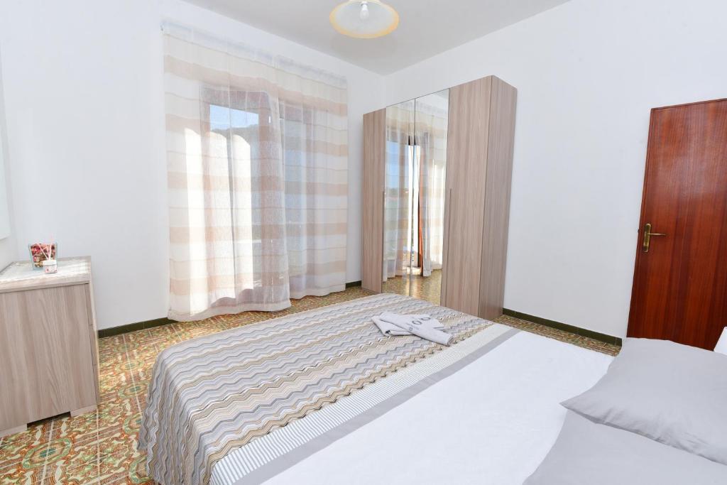 ein Schlafzimmer mit einem großen Bett in einem Zimmer mit Fenstern in der Unterkunft La Terrazza sugli Dei in Pianillo