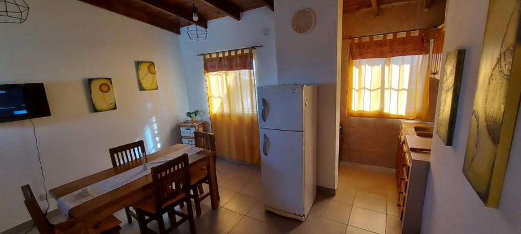 cocina y comedor con nevera y mesa en DEPARTAMENTO ORTEGA Junin, en Junín
