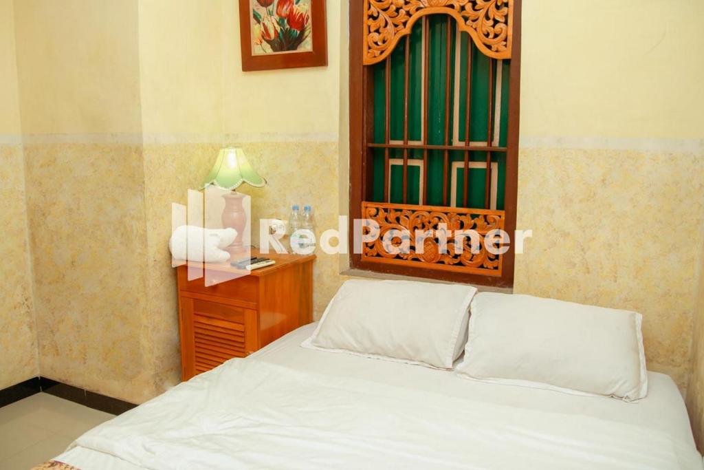 Postel nebo postele na pokoji v ubytování Flamboyan Asri Syariah Mitra RedDoorz near Kampung Inggris Pare