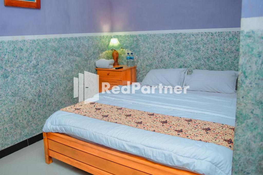 Postel nebo postele na pokoji v ubytování Flamboyan Asri Syariah Mitra RedDoorz near Kampung Inggris Pare