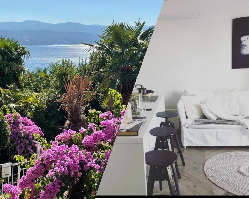 a living room with a view of the ocean and flowers at MyPalmasSuite with free parking in Opatija in Opatija