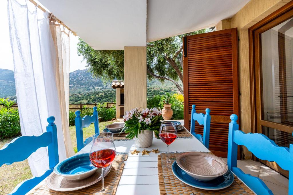 a table with two glasses of red wine on it at Ca Fiorini Vista Mare in Villasimius